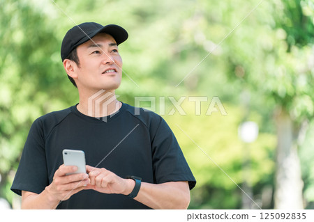 Health management with smartphone during exercise, middle-aged Asian man checking his health Health management with smartphone during exercise, middle-aged Asian man checking his health 125092835