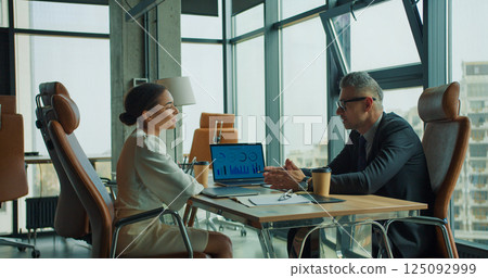 Business discussion in modern glass office setting 125092999