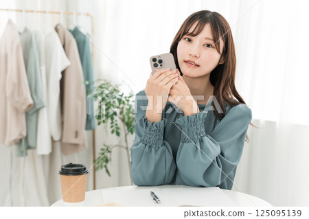 Young Asian business woman using a smartphone in the office Young Asian business woman using a smartphone in the office 125095139