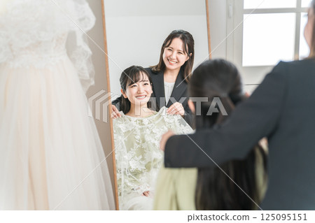 A Japanese woman trying on a wedding dress and coming to a meeting 125095151