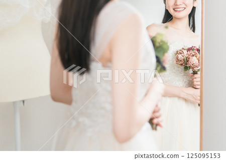 A woman trying on a wedding dress, choosing a wedding bouquet, and having a meeting to select a bouquet 125095153