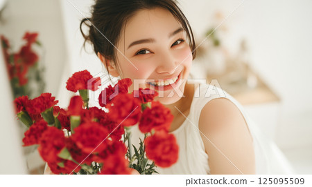 母親節那天,一位微笑的母親收到了一束康乃馨 母親節那天,一位微笑的母親收到了一束康乃馨 125095509