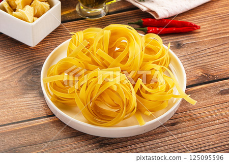 Raw dry Italian pasta - pappardelle 125095596