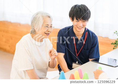 Young Asian male staff and senior woman working in rehabilitation facility, nursing home Young Asian male staff and senior woman working in rehabilitation facility, nursing home 125096229