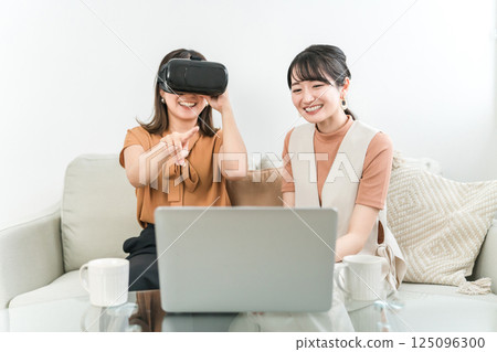 Asian woman wearing VR goggles playing games, experiencing virtual reality, and operating the device (AR, MR) Asian woman wearing VR goggles playing games, experiencing virtual reality, and operating the device (AR, MR) 125096300