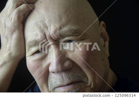 Close-up of an elderly man's troubled face 125096314
