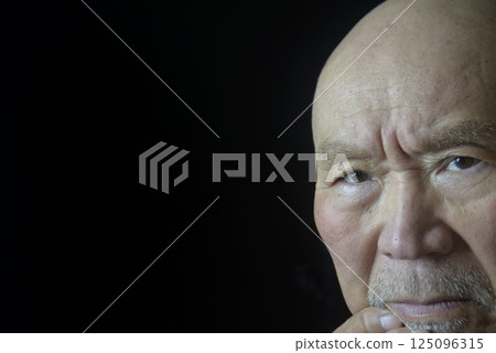 Close-up of an elderly man's troubled face 125096315
