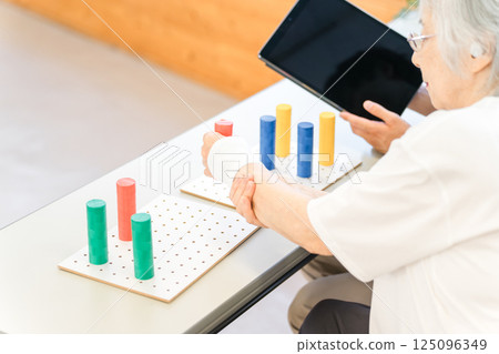 Senior woman training in rehabilitation (stroke, hemiplegia, sequelae) Senior woman training in rehabilitation (stroke, hemiplegia, sequelae) 125096349