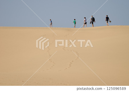 Family walking on a dune. 125096589