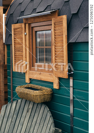 Empty Wicker Flowerpot Hanging Under The Window Of A Wooden House, Exterior Design 125096592