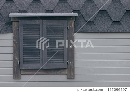 Gray wood plank facade with window closed with wooden shutters Gray wood plank facade with window closed with wooden shutters 125096597