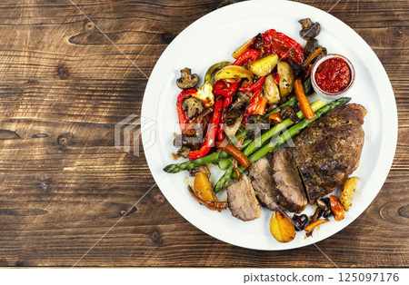 Delicious fried duck breast on wooden surface. 125097176
