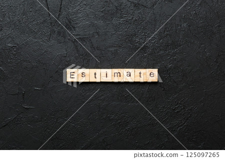 estimate word written on wood block. estimate text on table, concept 125097265