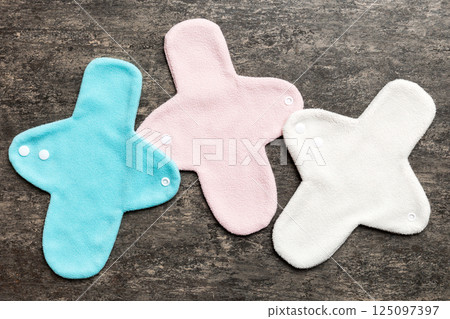 Eco-friendly reusable fabric women's pads. set of colorful bright reusable menstrual pads. zero waste woman periods concept top view with copy space Eco-friendly reusable fabric women's pads. set of colorful bright reusable menstrual pads. zero waste woman periods concept top view with copy space 125097397