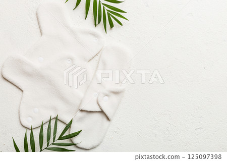 lean feminine sanitary napkin with green leaf. Absence of menstruation in woman. Minimal concept of female menopause. Copy space top view lean feminine sanitary napkin with green leaf. Absence of menstruation in woman. Minimal concept of female menopause. Copy space top view 125097398