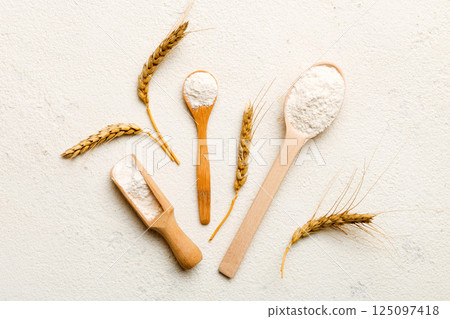 Flat lay of Wheat flour in wooden bowl with wheat spikelets on colored background. world wheat crisis 125097418