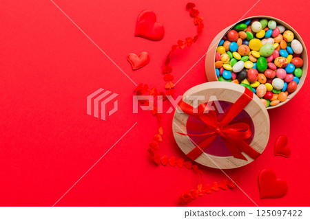 Valentine day composition: sweet candy, with gift boxes with bow and red felt hearts, photo template, background. Top View with copy space Valentine day composition: sweet candy, with gift boxes with bow and red felt hearts, photo template, background. Top View with copy space 125097422