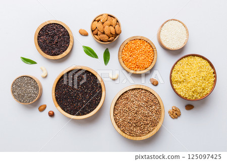 Various superfoods in smal bowl on colored background. Superfood as rice, chia, quinoa, lentils, nuts, sesame seeds, almonds. top view copy space Various superfoods in smal bowl on colored background. Superfood as rice, chia, quinoa, lentils, nuts, sesame seeds, almonds. top view copy space 125097425