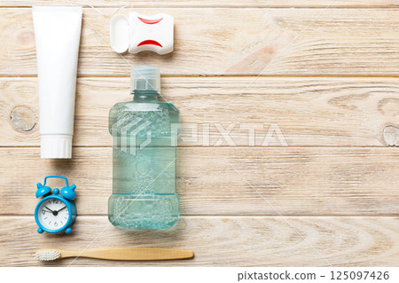 Mouthwash and other oral hygiene products on colored table top view with copy space. Flat lay. Dental hygiene. Oral care products and space for text on light background. concept 125097426