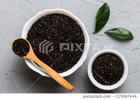 quinoa seeds in bowl and spoon on colored background. Healthy kinwa in small bowl. Healthy superfood 125097444
