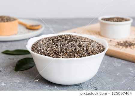 Chia seeds in bowl and spoon on colored background. Healthy Salvia hispanica in small bowl. Healthy superfood Chia seeds in bowl and spoon on colored background. Healthy Salvia hispanica in small bowl. Healthy superfood 125097464