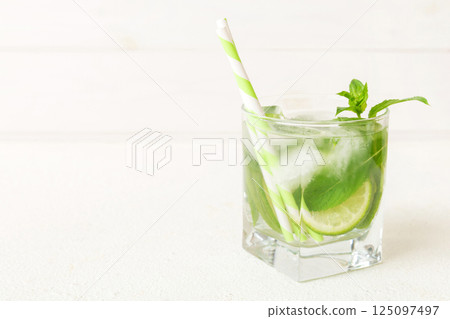 Mojito cocktail. Refreshing mojito cocktail with lime, lemon and mint in a tall glass with a stick 125097497
