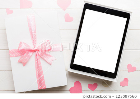 Gift box of open tablet for the holidays with a bow top view 125097560