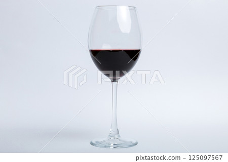 One glasses of red wine at wine tasting. Concept of red wine on colored background. Top view, flat lay design One glasses of red wine at wine tasting. Concept of red wine on colored background. Top view, flat lay design 125097567