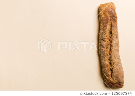 Minimalist french baguette on colored background. fresh bread as background, top view with space for your text or design Minimalist french baguette on colored background. fresh bread as background, top view with space for your text or design 125097574