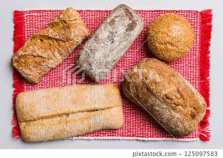 Assortment of freshly baked bread with napkin on rustic table top view. Healthy unleavened bread. French bread 125097583