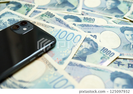 Many 1,000 yen bills and a smartphone 125097932
