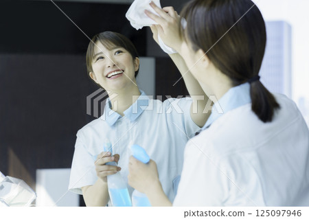 一名年輕的女清潔工正在擦拭辦公大樓衛浴的鏡子。照片提供：東京電子專門學校、電波學園 125097946