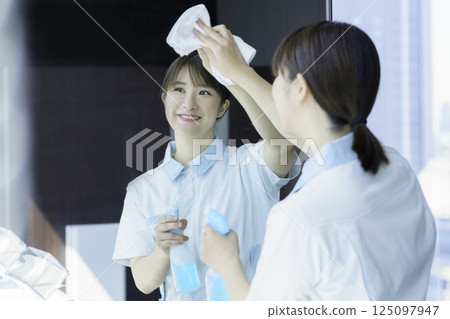 一名年輕的女清潔工正在擦拭辦公大樓衛浴的鏡子。照片提供:東京電子專門學校、電波學園 一名年輕的女清潔工正在擦拭辦公大樓衛浴的鏡子。照片提供:東京電子專門學校、電波學園 125097947