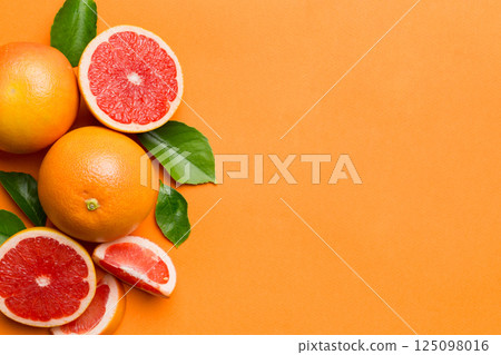 fresh Fruit grapefruit with Juicy grapefruit slices on colored background. Top view. Copy Space. creative summer concept. Half of citrus in minimal flat lay with copy space 125098016