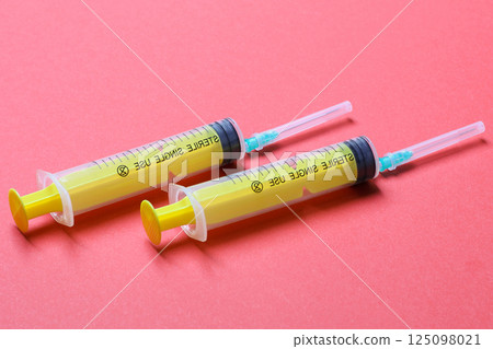 Top view of syringes in a row for medical injection on colorful background with copy space. Health and vaccination concept 125098021