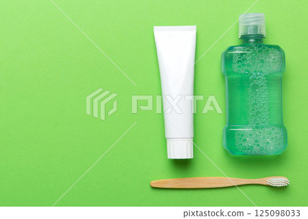 Mouthwash and other oral hygiene products on colored table top view with copy space. Flat lay. Dental hygiene. Oral care products and space for text on light background. concept Mouthwash and other oral hygiene products on colored table top view with copy space. Flat lay. Dental hygiene. Oral care products and space for text on light background. concept 125098033