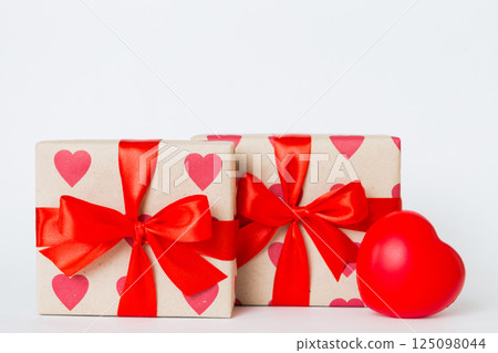 gift box with red bow and red heart on colored background. Perspective view. Flat lay 125098044