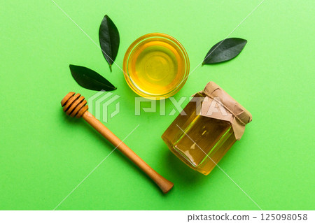 Honey jar with wooden honey dipper on white background top view with copy space. Delicious honey bottle 125098058