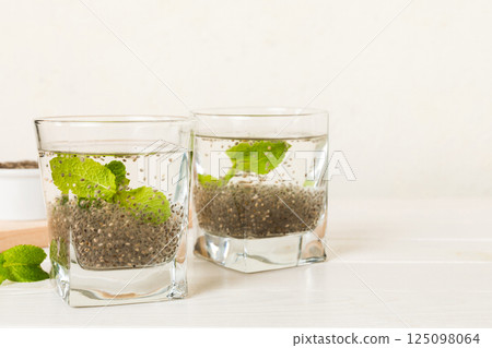 Healthy breakfast or morning with chia seeds lemon and mint on table background, vegetarian food, diet and health concept. Chia pudding with lemon and mint 125098064