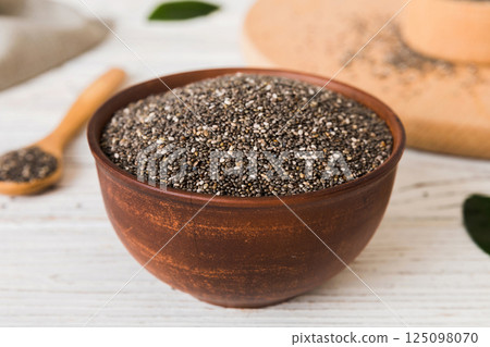 Chia seeds in bowl and spoon on colored background. Healthy Salvia hispanica in small bowl. Healthy superfood 125098070