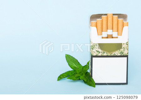 Pack of menthol cigarettes and fresh mint on colored table, Menthol cigarettes top view flat lay Pack of menthol cigarettes and fresh mint on colored table, Menthol cigarettes top view flat lay 125098079