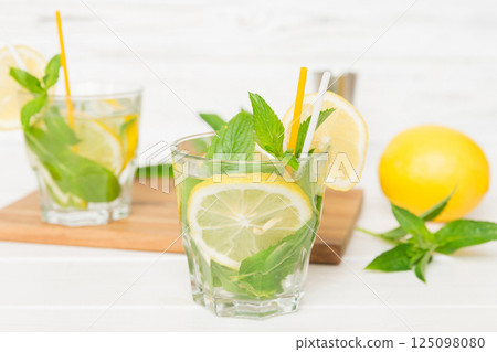 Mojito cocktail. Refreshing mojito cocktail with lime, lemon and mint in a tall glass with a stick Mojito cocktail. Refreshing mojito cocktail with lime, lemon and mint in a tall glass with a stick 125098080