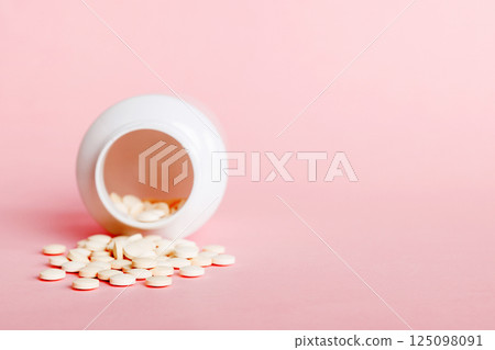 Medicine bottle and white pills spilled on a light background. Medicines and prescription pills flat lay background. White medical pills and tablets spilling out of a drug bottle Medicine bottle and white pills spilled on a light background. Medicines and prescription pills flat lay background. White medical pills and tablets spilling out of a drug bottle 125098091