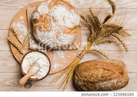 Freshly baked bread on cutting board against white wooden background. top view bread with copy space Freshly baked bread on cutting board against white wooden background. top view bread with copy space 125098160
