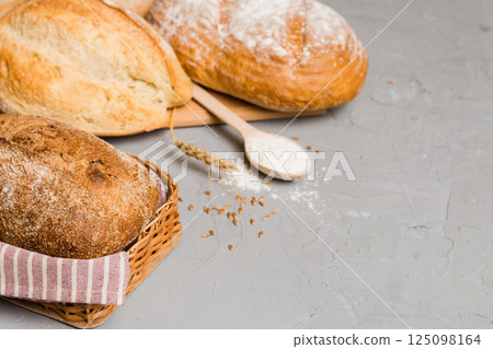 Homemade natural breads. Different kinds of fresh bread as background, perspective view with copy space Homemade natural breads. Different kinds of fresh bread as background, perspective view with copy space 125098164