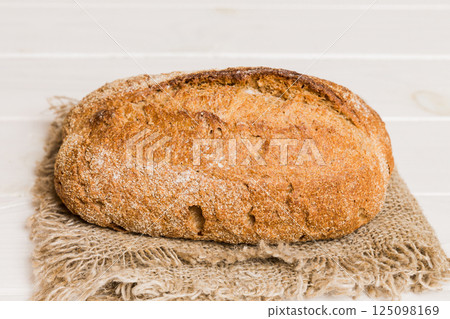 freshly baked bread with napkin on rustic table top view. Healthy white bread loaf isolated freshly baked bread with napkin on rustic table top view. Healthy white bread loaf isolated 125098169