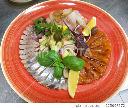 plate with sliced salmon, salted herring and sturgeon pieces 125098272