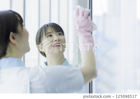 一名年輕的女清潔工正在擦拭辦公大樓衛浴的鏡子。照片提供：東京電子專門學校、電波學園 125098517