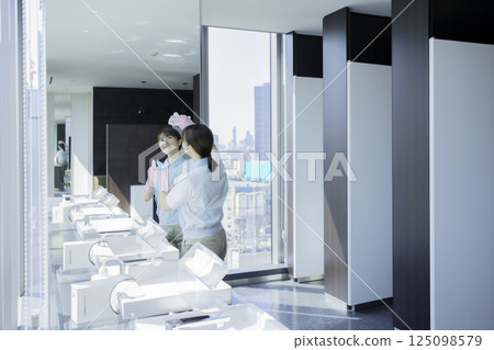 一名年輕的女清潔工正在擦拭辦公大樓衛浴的鏡子。照片提供：東京電子專門學校、電波學園 125098579