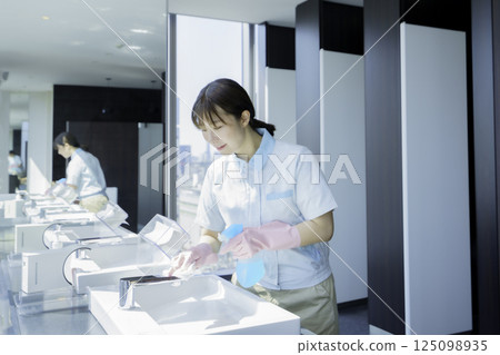 一名年輕的女清潔工正在擦拭辦公大樓浴室的水槽。照片提供:東京電子專門學校、電波學園 一名年輕的女清潔工正在擦拭辦公大樓浴室的水槽。照片提供:東京電子專門學校、電波學園 125098935